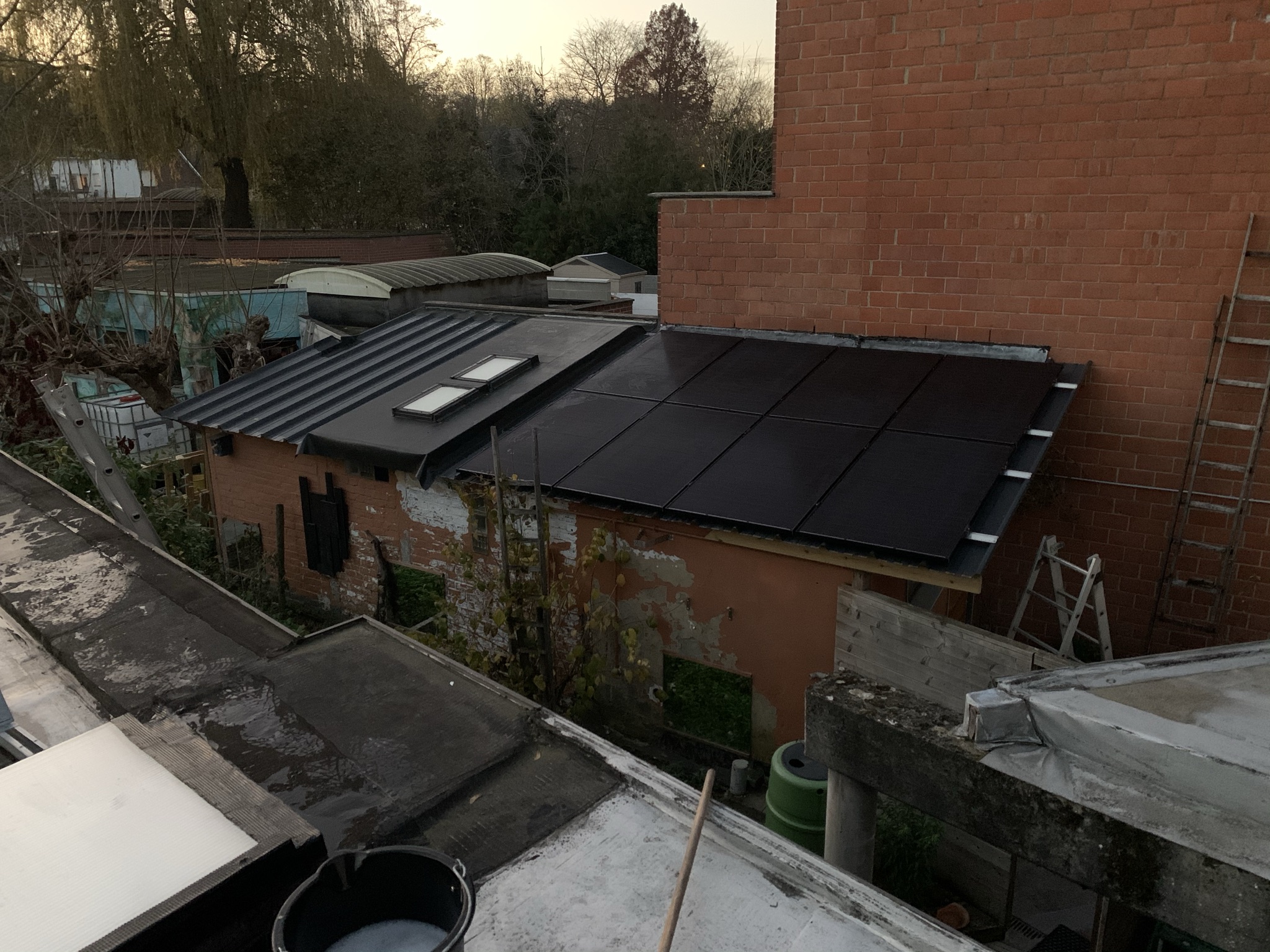 Zwarte zonnepanelen op het dak van een aanbouw